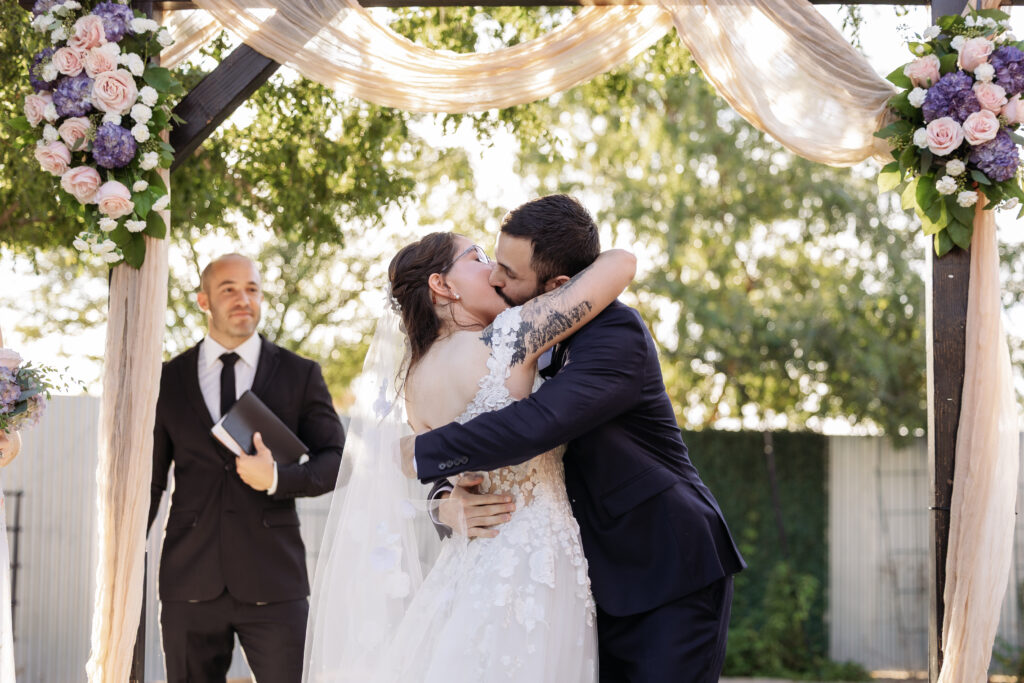 Bride and groom kissing during their Schnepf Farms wedding ceremony in Queen Creek, Arizona