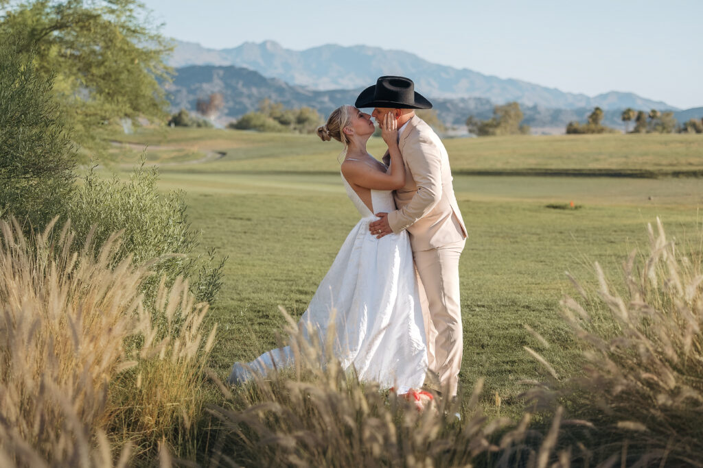 Katie and Darren kiss with the Lake Havasu mountains behind them