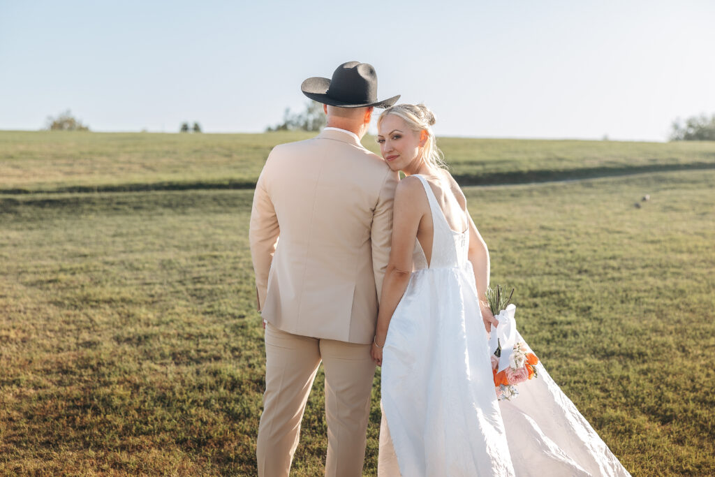 Katie looks toward the camera while standing with Darren after their London Bridge Resort ceremony.