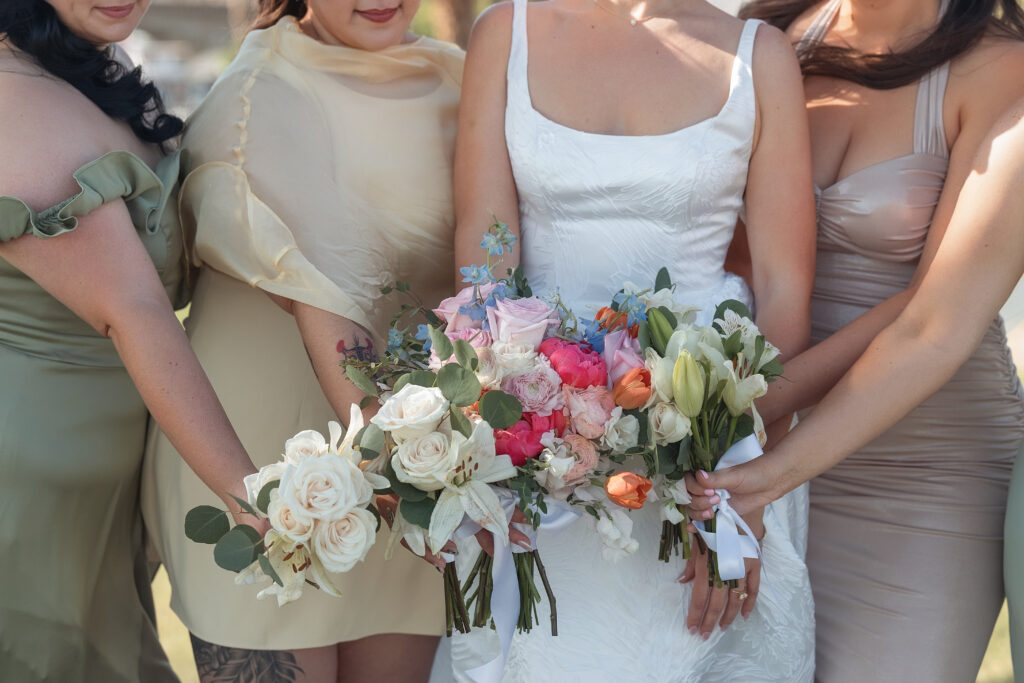 Katie and her bridesmaids raise their bouquets during wedding portraits in Lake Havasu.