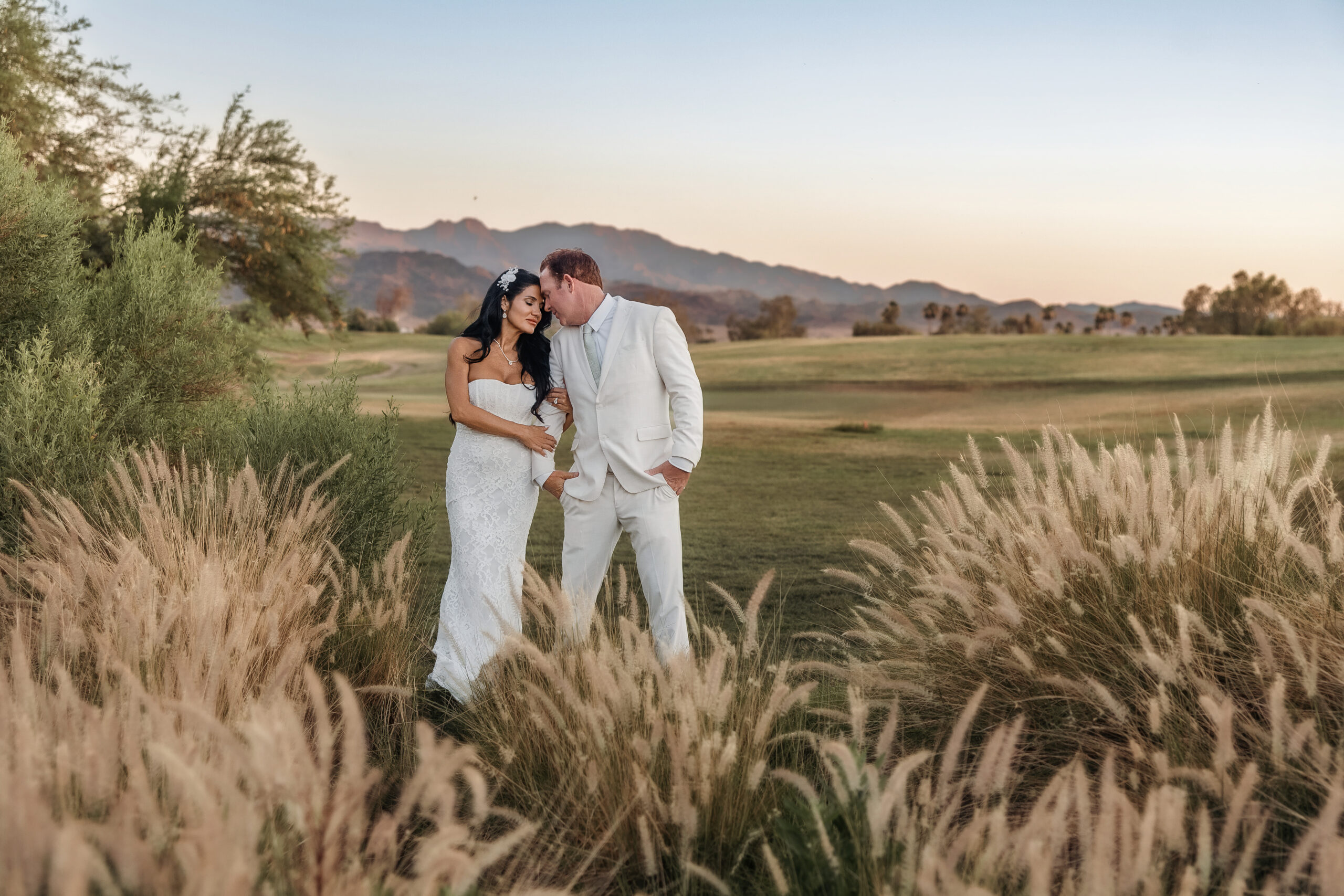 Paul and Lizzy during sunset portraits at their Lake Havasu wedding with Arizona mountains in the background