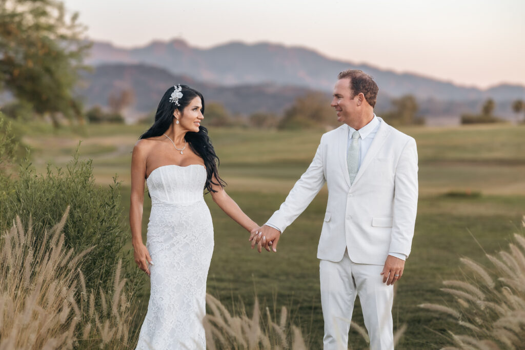 Paul and Lizzy holding hands during golden-hour wedding portraits with Arizona mountains in the background